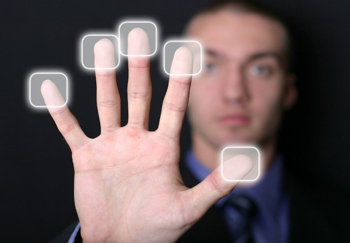 Man with palm facing outwards and fingertips activating screen